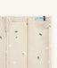 Close-up of a Newborn baby asleep in a bassinet under an ergoPouch HugMe Blanket 0.2 & 1.0 TOG in Daisy Sprinkle displaying the 0.2 TOG side