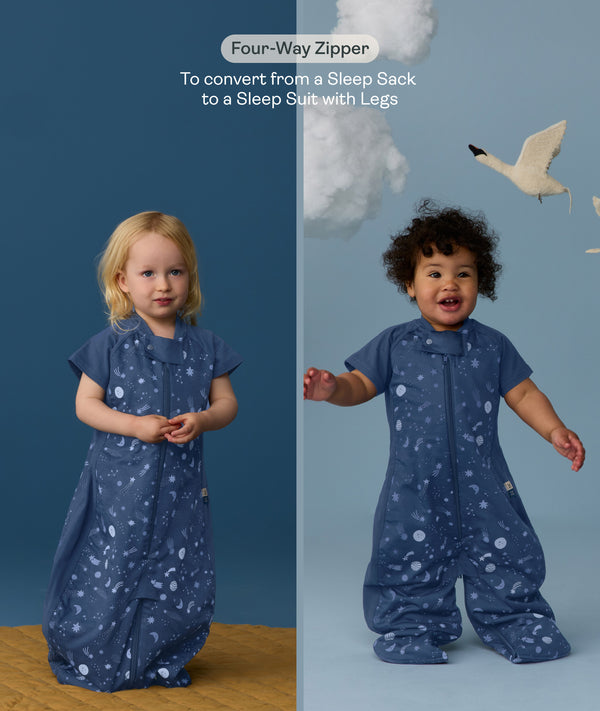 Two children wearing an ergoPouch Sleep Suit Sack 1.0 TOG Starbeam, a sleeping bag that converts to a sleep suit with legs by a four-way zipper feature. 
