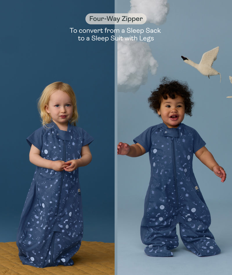 Two children wearing an ergoPouch Sleep Suit Sack 1.0 TOG Starbeam, a sleeping bag that converts to a sleep suit with legs by a four-way zipper feature. 