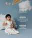 Child in an ergoPouch Sleep Sack 1.0 TOG Daydream sitting on a blue floor with clouds and a kite, surrounded by text about product features.