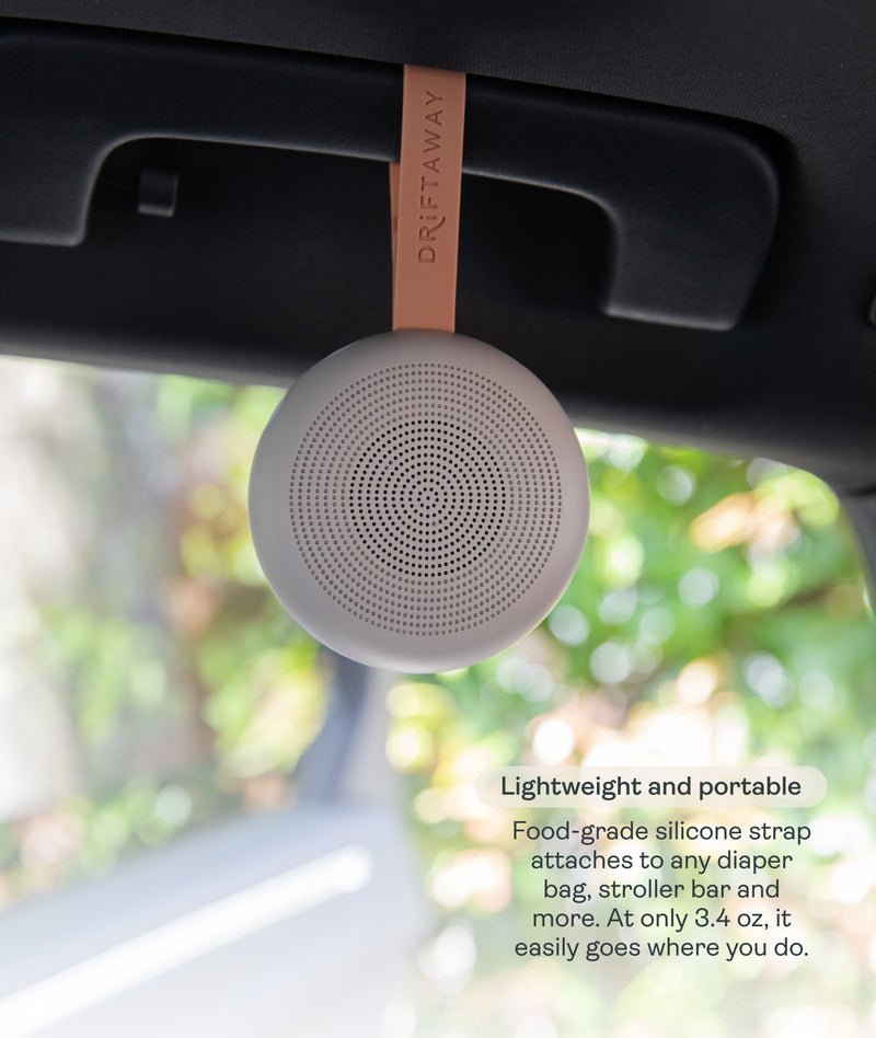 A lightweight, circular Drift Away White Nosie machine attached to a car handle. Text overlay titled 