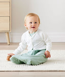 Baby sitting in an everyday ergoPouch Sleeping Sack with the added layer of Arm Warmers