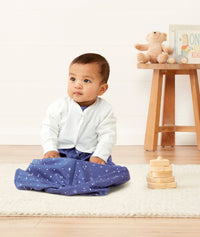 Baby sitting in an everyday ergoPouch Sleeping Sack with the added layer of Arm Warmers