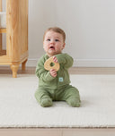 Newborn sitting in ergoPouch Long Sleeve Romper 1.0 TOG Moss