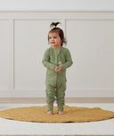 Infant standing in ergoPouch Long Sleeve Romper 1.0 TOG Moss