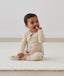 Infant sitting in ergoPouch Long Sleeve Romper 1.0 TOG Vanilla