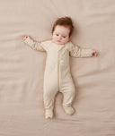 Newborn wearing an ergoPouch Long Sleeve Romper 1.0 TOG Vanilla