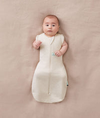 Baby sleeping with arms out in a ergoPouch Cocoon Swaddle Sack 1.0 TOG Oatmeal Marle