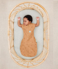 Baby sleeping with arms out in ergoPouch Cocoon Swaddle Sack 0.2 TOG Honey Bees