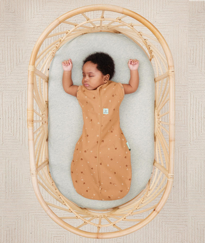 Baby sleeping with arms out in ergoPouch Cocoon Swaddle Sack 0.2 TOG Honey Bees