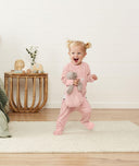 Infant standing wearing ergoPouch Long Sleeve Romper 1.0 TOG Berries