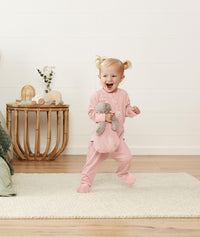 Infant standing wearing ergoPouch Long Sleeve Romper 1.0 TOG Berries
