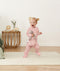 Infant standing wearing ergoPouch Long Sleeve Romper 1.0 TOG Berries