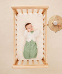 Newborn sleeping in crib with Cocoon Swaddle 1.0 TOG Willow, Butterfly Cardi Oatmeal Marle, Long Sleeve Romper Vanilla with a White Noise Machine