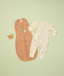 Flatlay of ergoPouch Long Sleeve Romper 0.2 TOG Critters and Cocoon Swaddle 0.2 TOG Honey Bees