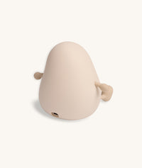 Rear view of a soft-touch silicone bedtime lamp shaped like a rounded character with small arms and legs, showing a charging port at the base.