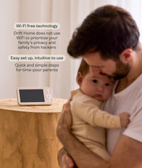 Man holding a child next to the ergoPouch Drift Home Baby Monitor and Smart TOG Guide that uses Wi-Fi-free technology to prioritize family privacy