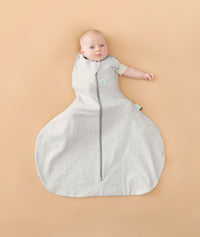 Baby wearing a ergoPouch Hip Harness Cocoon Swaddle Sack 1.0 TOG Grey Marle, transitioning to arms out sleeping