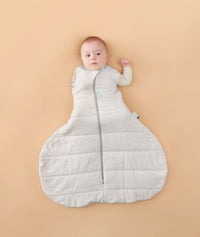 Baby wearing a ergoPouch Hip Harness Cocoon Swaddle Sack 2.5 TOG Grey Marle, transitioning to arms out sleeping