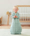 Smiling infant wearing a long sleeve warm ergoPouch Sleep Sack 3.5 TOG in Sage