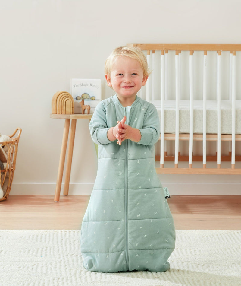 Smiling infant wearing a long sleeve warm ergoPouch Sleep Sack 3.5 TOG in Sage