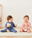 Two babies sitting wearing ergoPouch Long Sleeve Romper 1.0 TOG Night Sky and Berries