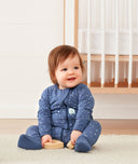 Infant sitting wearing ergoPouch Long Sleeve Romper 1.0 TOG Night Sky