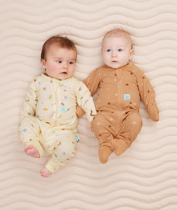 Two newborns wearing  ergoPouch Long Sleeve Romper 0.2 TOG Critters and Honey Bees