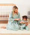Mom wearing a an ergoPouch Matchy Matchy Robe Sage, playing with a toddler in a matching color Sleep Suit Sack