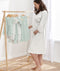 Mom wearing a an ergoPouch Matchy Matchy Robe Daisies, embracing her baby bump