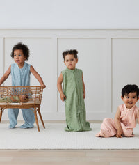 Three children playing in ergoPouch Jersey Sleep Suit Sack 0.2 TOG Willow, Dragonflies and Daisies, a light sleeping bag that converts to a sleeping bag with legs