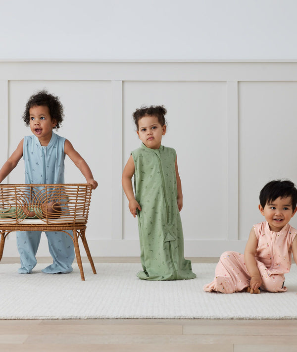 Three children playing in ergoPouch Jersey Sleep Suit Sack 0.2 TOG Willow, Dragonflies and Daisies, a light sleeping bag that converts to a sleeping bag with legs