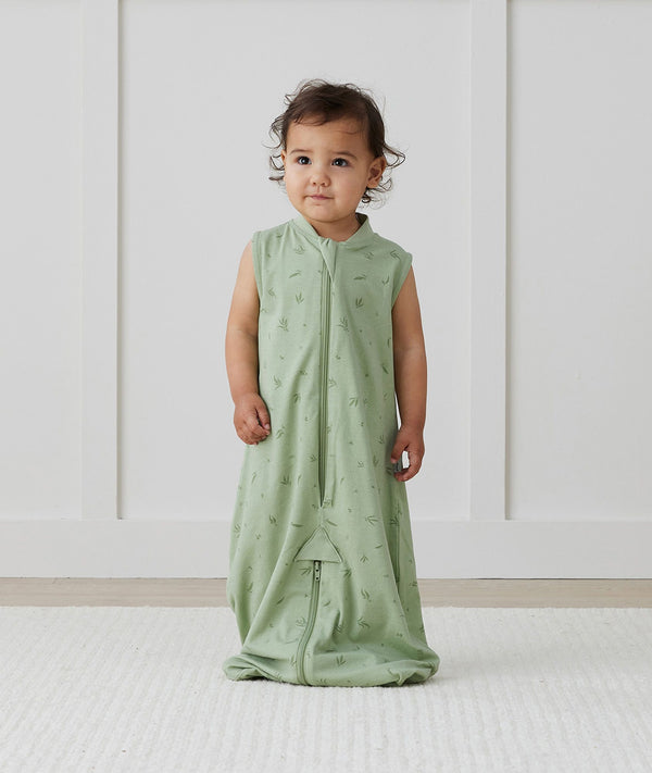 Child standing in ergoPouch Jersey Sleep Suit Sack 0.2 TOG Willow, a light sleeping bag that converts to a sleeping bag with legs