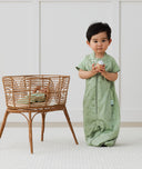 Child standing in an ergoPouch Sleep Suit Sack 1.0 TOG Willow, a sleeping bag that converts to a sleeping bag with legs