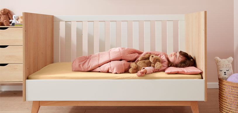 Toddler sleeping in bed after transitioning from crib