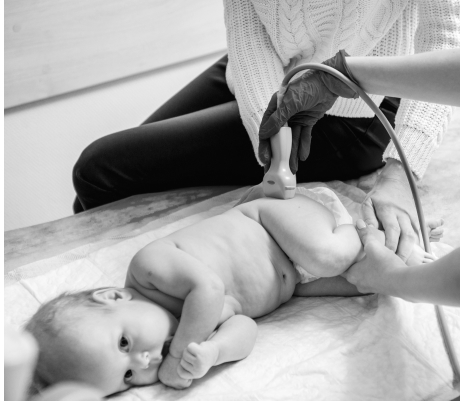 Doctor performing an ultrasound on baby's hip