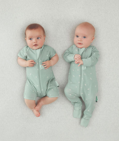 Two babies in short and long sleeve pajamas