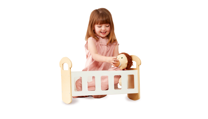 Toddler playing with doll, rehearsing bedtime routine